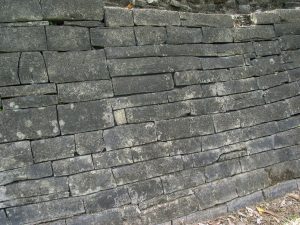 Photo close up of stacked and fitted stones making up a wall.